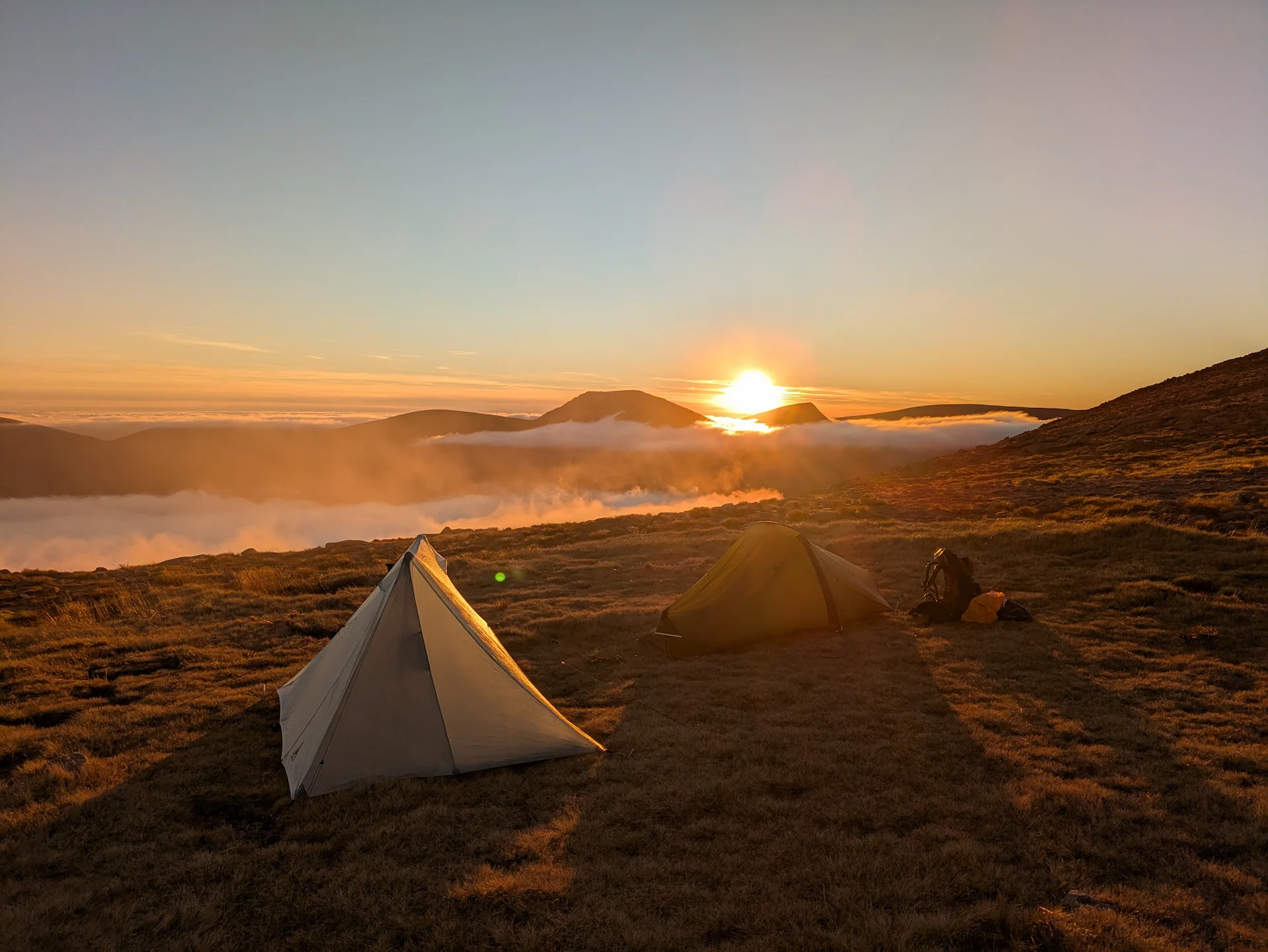 Two backpacking tents at sunset above the clouds in the Southern Cairngorms